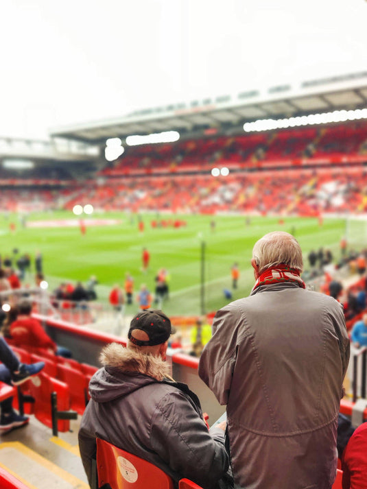 two football fans waiting for liverpool to come onto the pitch